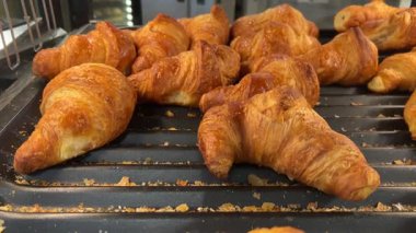 Süpermarketteki self-servis rafında sergilenen yeni pişmiş kruvasanların üzerindeki görüntüler.