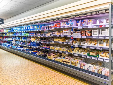 Fossano, İtalya - 22 Ağustos 2025. Süt ürünleri, krema ve yoğurt içeren büyük soğutmalı vitrin. Lidl indirim mağazasının koridorunda..