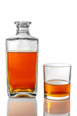 Sürahinin yanındaki viski bardağının yanında beyaz üzerine izole edilmiş viski şişesi ve kırpma yolu da dahil.