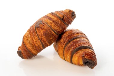 Başka bir kruvasanın üzerine yerleştirilmiş çikolatalı kruvasan. Kırpma yolu olan beyaz bir kruvasana izole edilmiş.