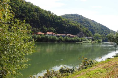 Mali Zvornik, Sırbistan, 29 Eylül 2022. Banja Koviljaca yakınlarındaki Drina nehri, Sırbistan 'ın BH kıyılarının manzarası. Suyun akışı, nehrin karşı kıyısındaki yeşillik. Yerleşim yerleri