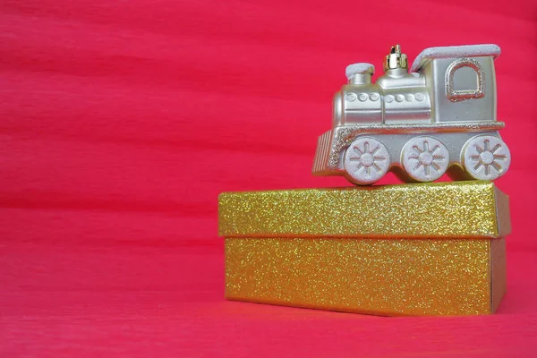 황금색 장난감 열차의 기관차와 상자는 빨간색 분홍색 바탕에 새해나 크리스마스 — 스톡 사진