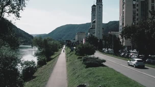 ズヴォルニク ボスニア ヘルツェゴビナ 2022年10月1日 Bihの主要道路M19 道路には車や人がいます 道路交通だ 町民の日常生活 複数階建ての教会の建物 ドリナ川 — ストック動画