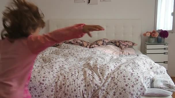 머리를 소녀가 시작하는 호텔의 침대에서 뛰어내렸습니다 아이는 분홍색 잠옷을 있습니다 — 비디오