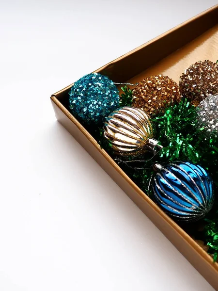 ギフトボックスの蓋にトレンディなクリスマスの装飾 カラフルなボールとティンセル ギフトや収納のための光沢のあるベージュまたはブラウンボックス 新年のクリスマスカード コピースペース — ストック写真