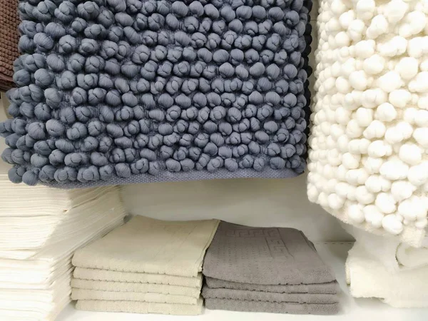 白色和灰色的微纤维浴垫挂在商店柜台上 斯堪的纳维亚内部风格 针织粉刺的软垫织物长方形地毯 浴室的装修与现代设计 — 图库照片
