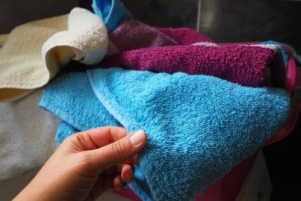 一个女人的手在摸一个有脏衣服的篮子里的棉布毛巾 洗衣店分拣和洗涤 洗衣房或浴室 粉红和蓝色毛绒毛巾 — 图库照片