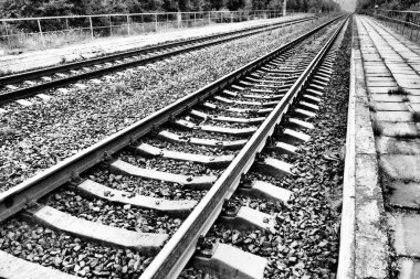 Demiryolları. Metal çelik korkuluklar ve ahşap uykucular. Demiryolunda perçin ve perçin var. Demiryolu raylarının taşlı dolgusu