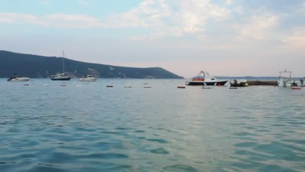 Herceg Noviモンテネグロ 2022年8月8日 海のビーチ休暇 海の旅と釣り 船は山を背景に海に浮かぶ 曇った天気 アドリア海 地中海旅行ビジネス — ストック動画