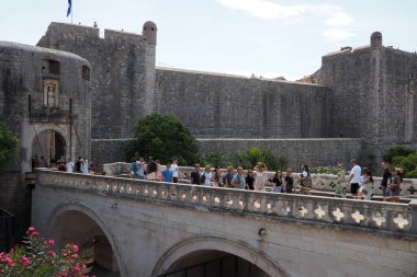 Pile Gate Dubrovnik Hırvatistan 14 Ağustos 2022 Erkekler ve kadınlar taş köprü boyunca Eski Şehir 'in kapısına yürüyorlar. Turist kalabalığı. Yoğun giriş. Eski şehrin ana girişi, işlek Yığın Kapısı