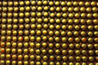 Siyah ve altın metalden yapılmış sivilceler ya da çiviler. Metal büyük yuvarlak çıkıntılar geometrik olarak yerleştirilmiştir. Sıra dışı endüstriyel zincir posta arkaplanı