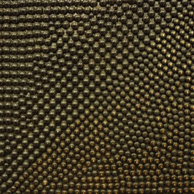 Siyah ve altın metalden yapılmış sivilceler ya da çiviler. Metal yuvarlak çıkıntılar rastgele yerleştirilmiş. Alışılmadık soyut arkaplan