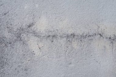 Alçılı duvar dokusu. Beyazlatıcı yüzey. Soyut arkaplan. Retro duvar yapı dokusu inşa etti. Beton duvarda çatlaklar ve tümsekler var. Su bazlı boyayla renklendirilmemiş. Eski püskü alçı..