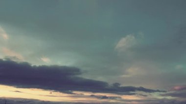 Renkli kara bulutlu sarı turuncu gün batımı. Mavi, mor, turkuaz yağmur bulutları ışık ufkunda dönüyor. Kümülüs bulutlarının altında siyah bir iplik bulutu uçar. Hızlı atış. Zaman aşımı