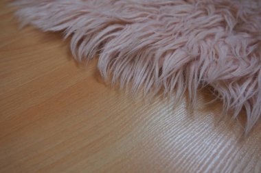 Bej kaplamalı yerde pembe halı var. Bir kız ya da kadının yatak odası ya da odası için kadınsı bir iç mekan. Pembe tonlarda iç dizayn. Döşeme lamine. Alerjide toz akarlarının rolü