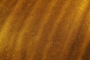 Altın parıltılarının Bokeh ışığı. Altın parıltı dokusu arka planı. Pullu ve pırıltılı, ışıltılı ambalaj kağıdı. Şenlikli altın bokeh ve parıltı. Çapraz çizgiler ve dalgalar.