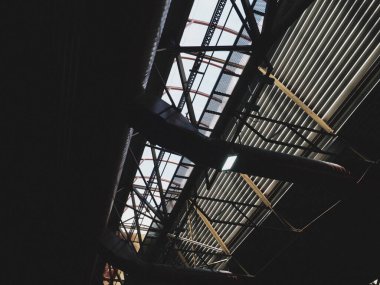 Bir hangarın çatısı, bir üretim salonu veya bir spor salonu. Metal yapılar, kirişler, destekleyici elementler. Büyük salon ve odalardaki havalandırma sistemleri. Çatı pencereleri. Endüstriyel iç