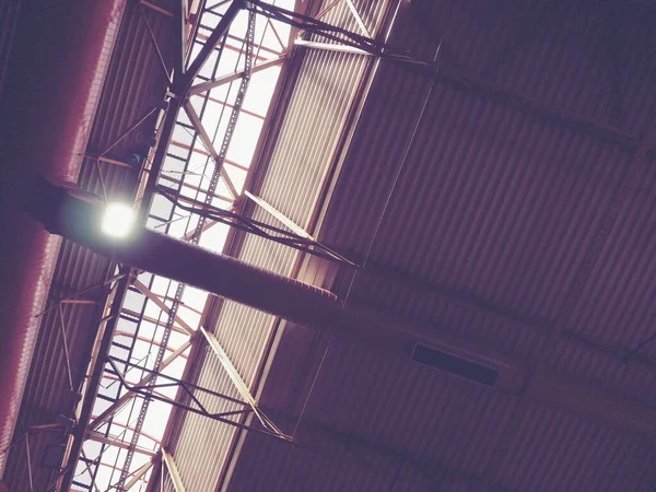 The roof of a hangar, a production hall or a sports hall. Metal structures, beams, supporting elements. Ventilation systems in large halls and rooms. Skylights. Industrial interior
