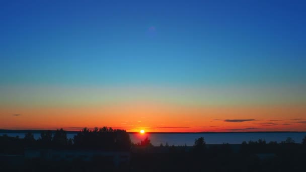 橘红色的黎明和夏天的日出 日出和太阳圆盘的升起在地平线之上 升起的太阳乌云让位给晴朗的蓝天 时间流逝4K 升起太阳盘 灿烂的阳光 — 图库视频影像