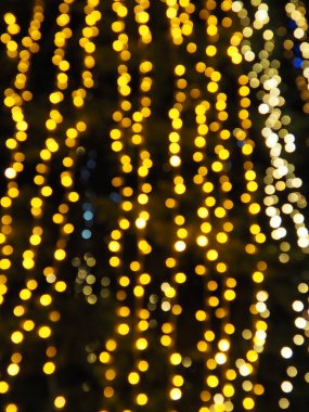 Kutlama çelengi. Şehir gece lambası bulanık Bokeh, odaklanmamış arka plan. Noel şakası. Karanlık gökyüzüne karşı güzel ışıklar. Yılbaşı ve Noel için sokak dekorasyonu.