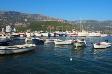 Budva, Karadağ, 15 Ağustos 2022 Adriyatik denizi, kıyı, dağlar, deniz dalgaları. Tekneler ve gemiler sete demirlediler. Su taşıma aracı. Turistik su aktiviteleriyle yaz tatili gezileri.