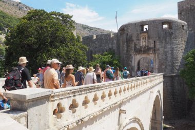 Pile Gate Dubrovnik Hırvatistan 14 Ağustos 2022 Erkekler ve kadınlar taş köprü boyunca Eski Şehir 'in kapısına yürüyorlar. Turist kalabalığı. Yoğun giriş. Eski şehrin ana girişi, işlek Yığın Kapısı