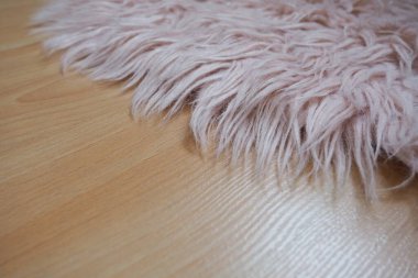 Bej kaplamalı yerde pembe halı var. Bir kız ya da kadının yatak odası ya da odası için kadınsı bir iç mekan. Pembe tonlarda iç dizayn. Döşeme lamine. Alerjide toz akarlarının rolü