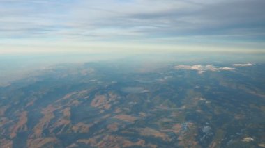 Turkey, Ankara. View from airplane window to the Turkish mountains, lakes and snowy peaks. Layered clouds and horizon. Lakes Saryar, Nallihan and Camlidere. Departure from Esenboga Havalimani Airport.