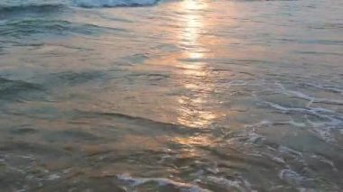 Sakin dalgalar kumlu sahilde yuvarlanıyor. Denizde ya da okyanusta gün batımı. Su hareketi. Dalgalar köpürüyor. Turist cenneti. Kum deniz suyundan görülebilir. Karadeniz 'de plaj tatili.