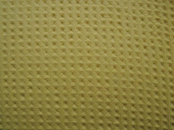 Sponge fibers sponge texture pattern surface close-up yellow brown background.