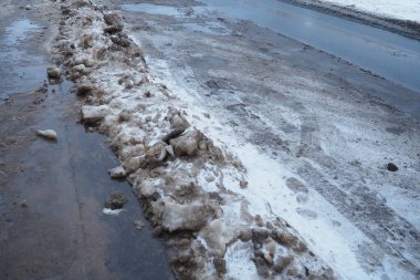 Yaya geçidinde kar, buz, çamur ve kış çamuru. Hava sıcaklığı yaklaşık 0 derece. Zorlu sürüş koşulları. Arabanın fren mesafesi. Trafik kanunları. Altyapı ve karayolu hizmetleri.