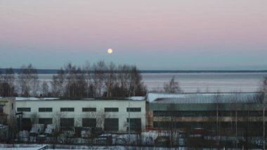 The Moon is the only natural satellite of the Earth. An accelerated video of the moonrise from behind Lake Onega. Evening turns into night. Disk full moon. The moon path is reflected in the water.
