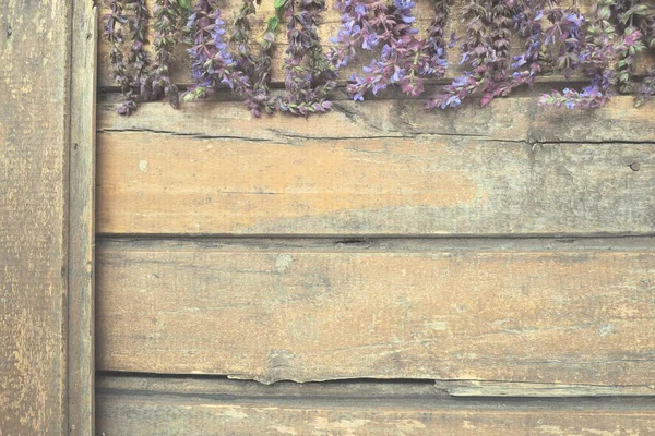 木製のテーブルの上にラベンダーとセージの花を閉じます 紫色と青の花とエッジの周りの葉を持つ暗い古い木の水平方向の板 まだ人生と平らなレイアウト テキストのための無料コピースペース — ストック写真