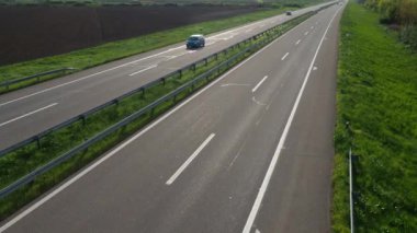 Sremska Mitrovica, Sırbistan, 30 Nisan 2022 Avrupa rotası E70 A-Sınıfı bir Batı-Doğu Avrupa rotasıdır. Birkaç araba asfalt dört şeritli bir otoyol boyunca sürer. Yol işaretleri. Pürüzlü tarla. Yeşil kenarlar.