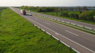 Sremska Mitrovica, Sırbistan, 30 Nisan 2022 Avrupa rotası E70 A-Sınıfı bir Batı-Doğu Avrupa rotasıdır. Erdogantur kamyonu ve arabalar asfalt dört şeritli otoyol boyunca ilerliyorlar. Yol işaretleri. Yeşil çimen.