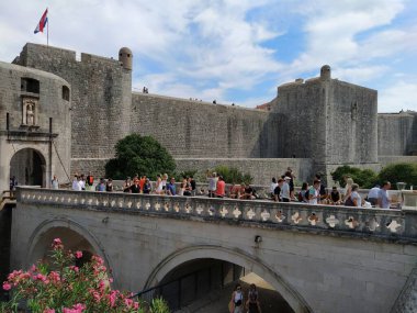 Pile Gate Dubrovnik Hırvatistan 14 Ağustos 2022 Erkekler ve kadınlar taş köprü boyunca Eski Şehir 'in kapısına yürüyorlar. Turist kalabalığı. Yoğun giriş. Eski şehrin ana girişi, işlek Yığın Kapısı