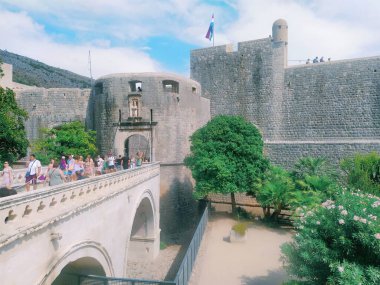 Pile Gate Dubrovnik Hırvatistan 14 Ağustos 2022 Erkekler ve kadınlar taş köprü boyunca Eski Şehir 'in kapısına yürüyorlar. Turist kalabalığı. Yoğun giriş. Eski şehrin ana girişi, işlek Yığın Kapısı