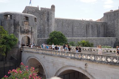 Pile Gate Dubrovnik Hırvatistan 14 Ağustos 2022 Erkekler ve kadınlar taş köprü boyunca Eski Şehir 'in kapısına yürüyorlar. Turist kalabalığı. Yoğun giriş. Eski şehrin ana girişi, işlek Yığın Kapısı