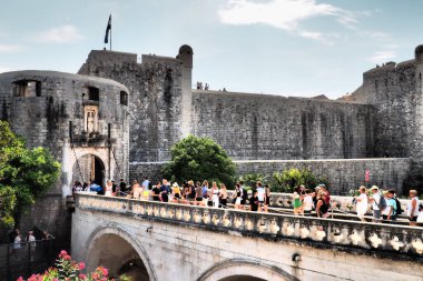 Pile Gate Dubrovnik Hırvatistan 14 Ağustos 2022 Erkekler ve kadınlar taş köprü boyunca Eski Şehir 'in kapısına yürüyorlar. Turist kalabalığı. Yoğun giriş. Eski şehrin ana girişi, işlek Yığın Kapısı