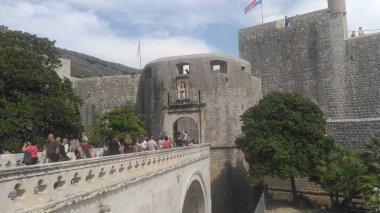 Pile Gate Dubrovnik Hırvatistan 14 Ağustos 2022 Erkekler ve kadınlar taş köprü boyunca Eski Şehir 'in kapısına yürüyorlar. Turist kalabalığı. Yoğun giriş. Eski şehrin ana girişi, işlek Yığın Kapısı
