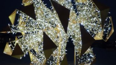 New Year and Christmas illumination of city streets. Flashing, flickering, shining, gleaming of electric bulbs and lights. Beautiful garlands and architectural forms. LED energy-saving garlands. Cone