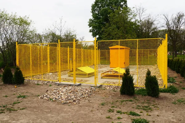 ground with tanks for liquefied gas. Modern gas installation with protective fencing. Yellow fence. Supply of gas to population. Connection of houses to energy. Gas and energy prices. Planted thuja.