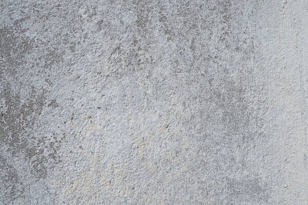 Plastered wall texture. Whitewash surface. Abstract background. Retro wall built structure texture. Cracks and bumps on the concrete wall. Uneven coloring with water-based paint. Old tattered plaster.