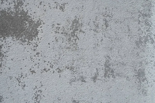 Plastered wall texture. Whitewash surface. Abstract background. Retro wall built structure texture. Cracks and bumps on the concrete wall. Uneven coloring with water-based paint. Old tattered plaster.