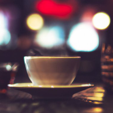 Kafede bir fincan sıcak çay. Anamorfik bokeh etkisi. Tilt-shift fotoğrafı. Güzel bir fincan ve çay tabağı içinde lezzetli aromatik çay. Çay soğuyor. Doğal aroma. Etiket ya da reklam. Buharlaşma