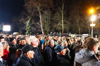 Sırp İlerleme Partisi SNS 'den Sremska Mitrovica Sırbistan 03.17.2023 Rallisi. Sırbistan Cumhuriyeti Cumhurbaşkanı Aleksandar Vuciç seçmenlere konuştu. Bir grup insan sahneyi izliyor..