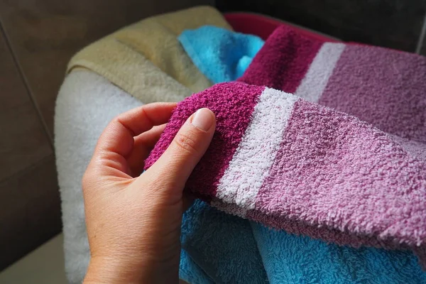 一个女人的手感觉到了一个有脏衣服的篮子里的棉布色毛巾 洗衣店分拣和洗涤 洗衣房或浴室 粉红和蓝色毛绒毛巾 — 图库照片