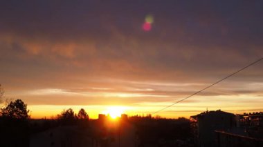 Güzel sarı turuncu kırmızı şafak ve sabah gündoğumu. Şehir ufkunun üzerinde güneş diskinin yükselişi. Yükselen güneş ve bulutlar. Güneş diskini kaldırma süresi 4K. Şehir manzarası. Sremska Mitrovica Sırbistan