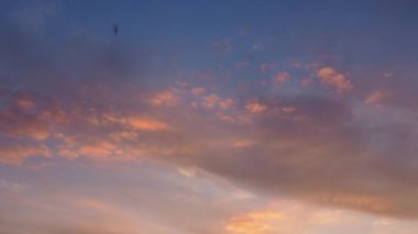 Sirus ve kümülüs bulutları batan güneş tarafından aydınlatılır ve sarıya, kırmızıya, pembeye dönüşür. 4K hızlandırılmış videoda rengarenk bulutlar değişiyor. Güzel gün batımı. Zaman aşımı.