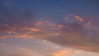 Sirus ve kümülüs bulutları batan güneş tarafından aydınlatılır ve sarıya, kırmızıya, pembeye dönüşür. 4K hızlandırılmış videoda rengarenk bulutlar değişiyor. Güzel gün batımı. Zaman aşımı.